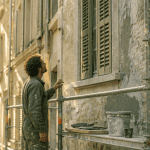Ravalement de façade tous les combien, artisan inspectant une façade ancienne